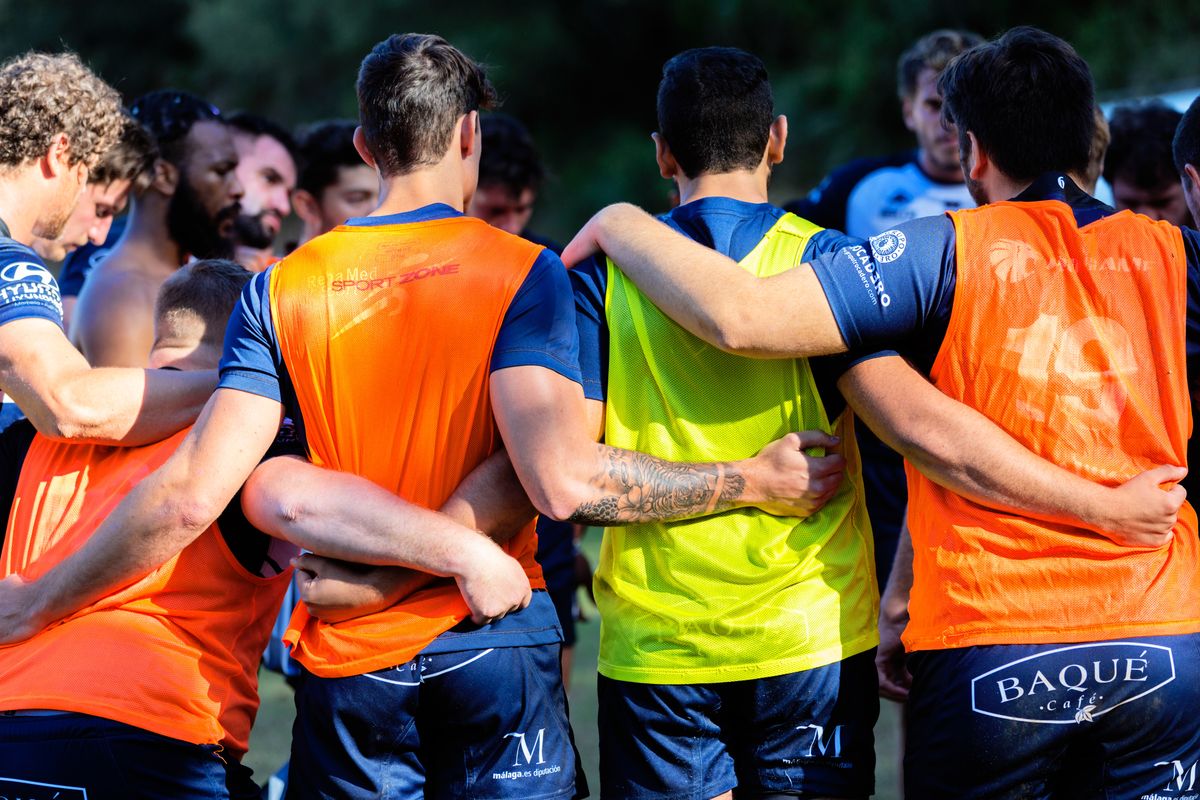 Back of soccer players embracing each other.